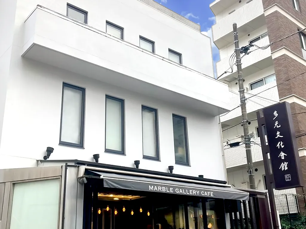 The exterior of Tagen Bunka Kaikan in Akasaka: a white building with MARBLE GALLERY CAFE on the first floor